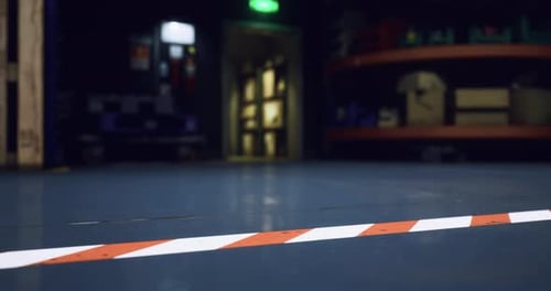 Warning Line on Warehouse Floor with Dim Lighting in the Background at Night