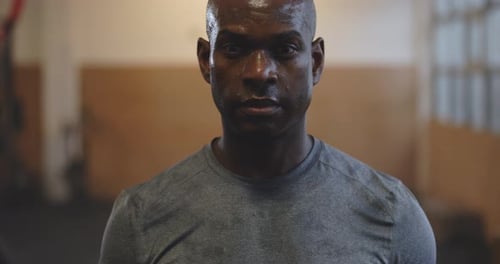 Fitter junger Afroamerikaner in Sportkleidung, der schwer atmet und dabei schwitzt