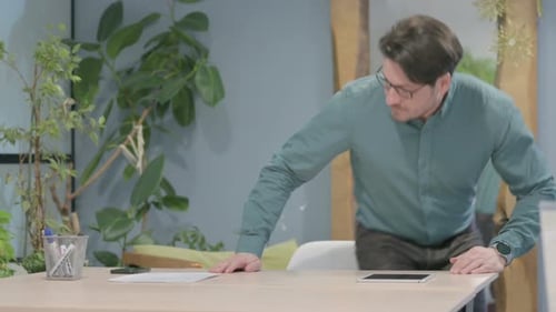 Hombre de mediana edad que regresa al escritorio de la oficina