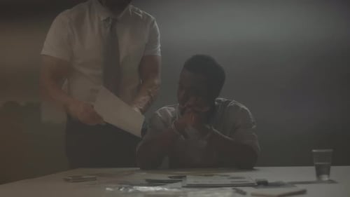 Man in Cuffs Being Questioned by Officer