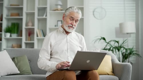 Senior Man on Laptop Video Call at Home