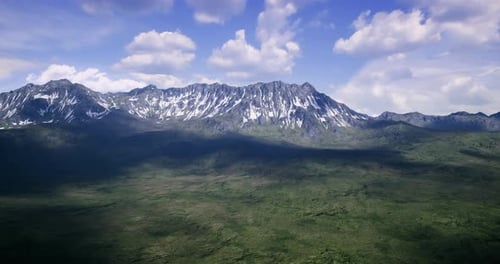 Majestic Mountain Range Exhibits Snow Capped Peaks and Lush Valleys