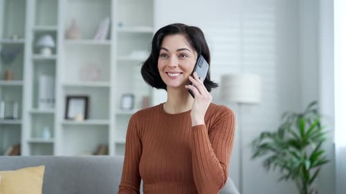 Young Woman Chatting on Smartphone at Home