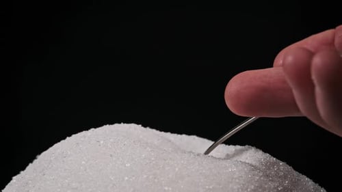 Getting Spoon Full of Sugar From Heap of Sugar on Black Background Slow Motion