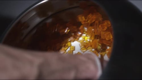 Orange gummy candy swirling in metal tube