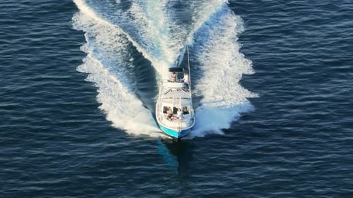A Speeding Boat Glides Gracefully Over the Clear Blue Waters on a Beautiful Sunny Day
