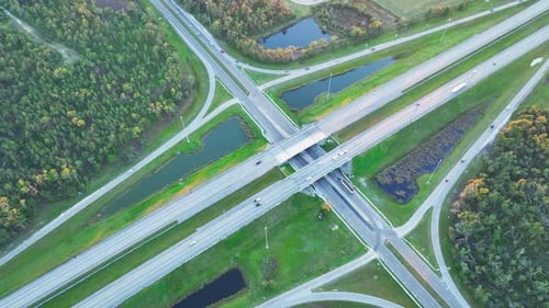 Aerial View of Freeway Overpass Junction with Fast Moving Traffic Cars and Trucks