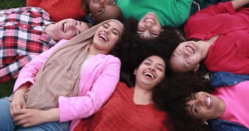 Group of Multiracial Female Friends Lying on Park Meadow and Having Fun