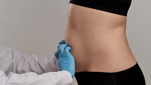 Healthcare Professional Examining Patient's Abdominal Area