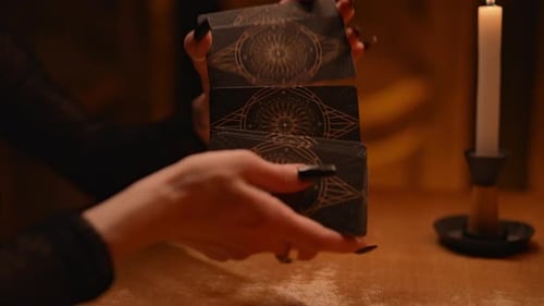 Hands Shuffling Tarot Cards with Candlelight