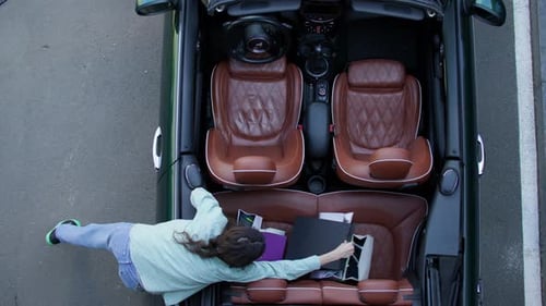 Woman Puts Shopping Bags in Convertible Car
