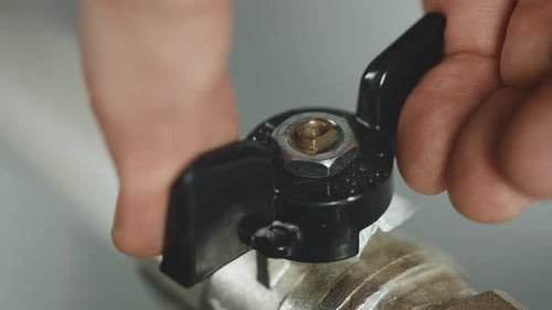 A Man Opens the Heat Supply to a Battery in a Residential Building a Closeup Hand Opens a Faucet