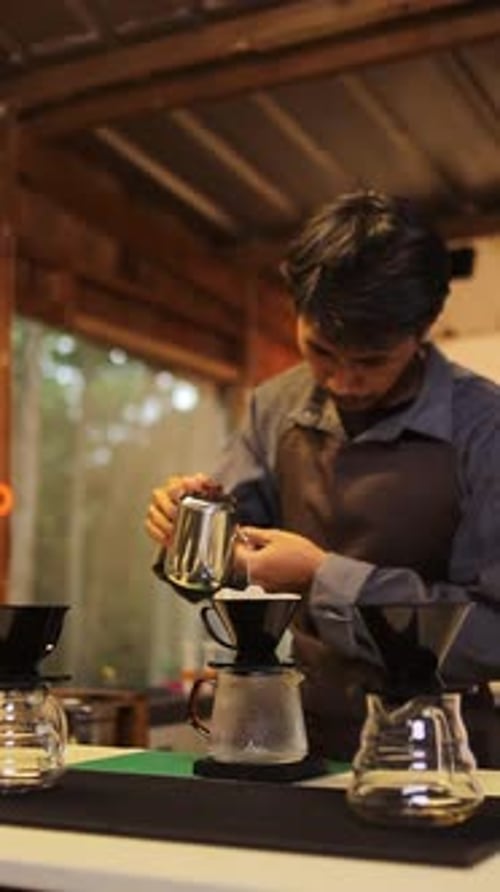 Skilled barista meticulously prepares pour over coffee crafting artisanal beverages with care