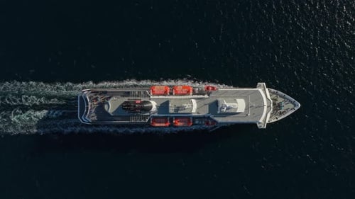 Drone view of ferry sailing across calm sea in daylight, Norway