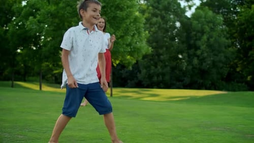 Smiling Mother Throwing Ball In Green Field. Pretty Girl Catching Ball. Positive Parents And Kids...