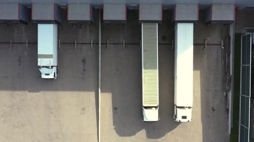 Logistikpark mit einem Lagerhaus - Ladeknotenpunkt. Sattelschlepper mit Güteranhängern, die an der Ramme stehen