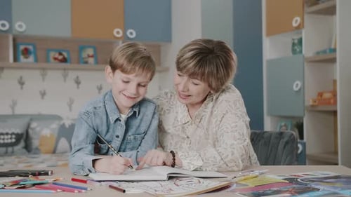 Grandma and grandson are doing homework. Portrait of a happy family. Learning at home. Teaching.