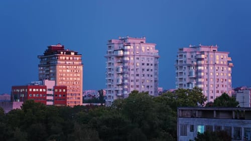 High rise apartments glow under the blue evening sky
