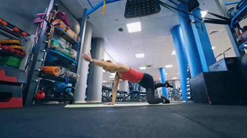 Young girl in sportswear training in the gym.