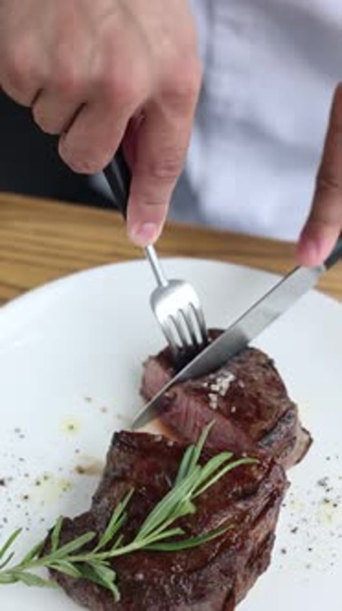 A man is eating a steak. Close-up