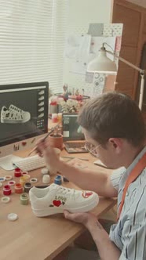 Male Artist Redesigning White Sneakers in Loft Studio