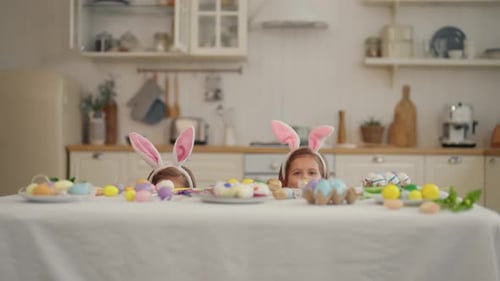 Twin Girls Celebrate Easter Holiday Twins Cheerful Children in Rabbit Bunny Ears Hiding at the Table