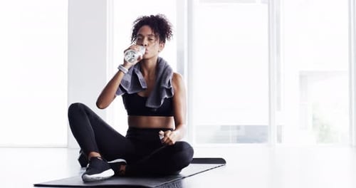 Woman drinking water, fitness and resting after workout, sports and tired with hydration