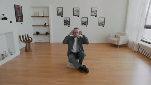 Mann setzt Kopfhörer in der Kunstgalerie auf
