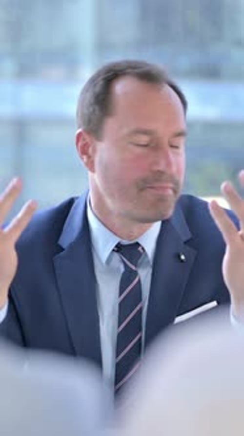 Professional Man in a Suit Talking to Colleagues