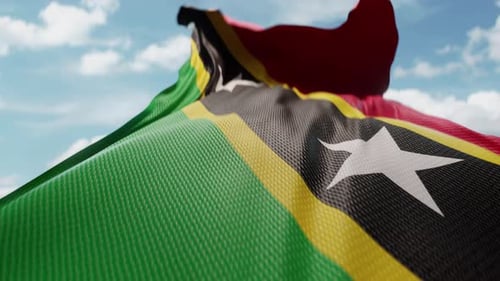 Realistic Waving Flag of Saint Kitts and Nevis Against Blue Sky
