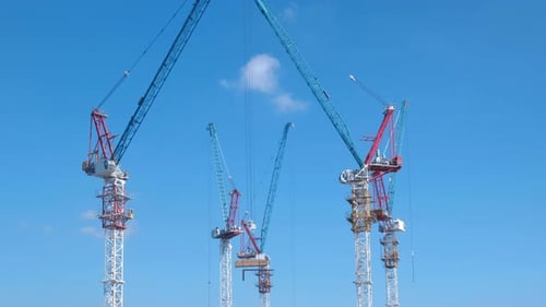 Aerial view of a large construction site with cranes at dusk. Timelapse.