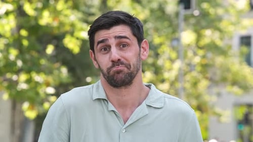 Happy Man in Shrugging Shoulders at City Park During Sunny Day