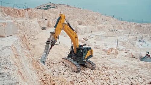 Excavator with Hydraulic Breaker in Stone Quarry