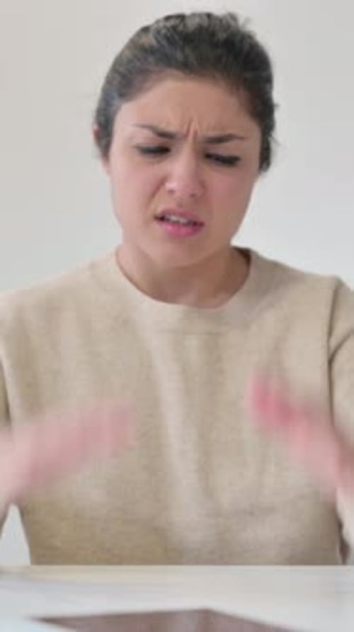 Frustrated Young Woman at Table Rubbing Temples