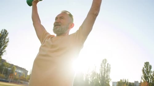 Old Caucasian Man Exercising with Dumbbells Muscle Sport City Stadium Outside Physical Activity
