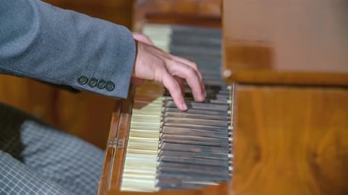 Close up shot focusing on pianist's hands while playing on the piano keyboard.