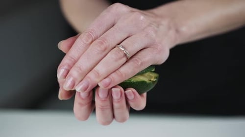 Female Hands Opening Ripe Avocado in a Half Slow Motion View of Organic Vegan Food Preparation