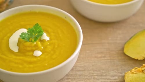 Bowl of Pumpkin Soup with Cream and Parsley
