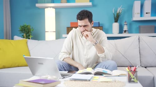Man looking at laptop worried and uneasy.