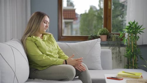 Young Woman Sitting Pensively on a Couch