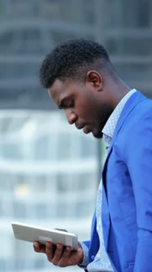 Focused Man Uses Tablet in a City Setting