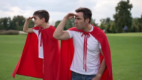 Father and Son Wearing Red Capes Outdoors