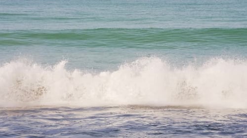Gentle ocean waves rolling and crashing on sandy shore