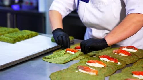 Unusual green crepes are rolled with cheese and salmon fish. T