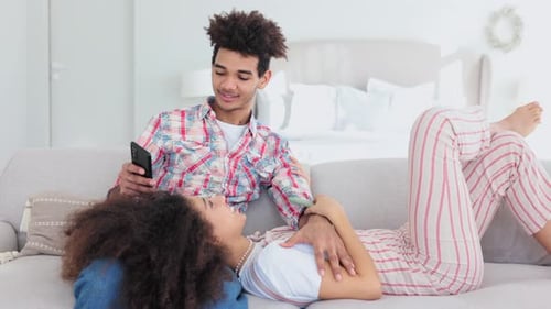 Young Couple Relaxing at Home with Phones