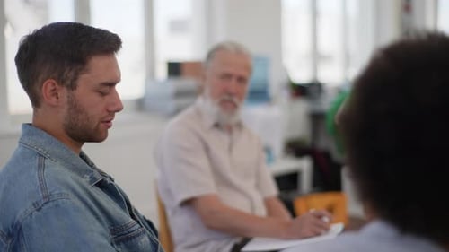 Closeup Side View Face of Depressed Young Bearded Man Talking About Mental State Sitting in Circle