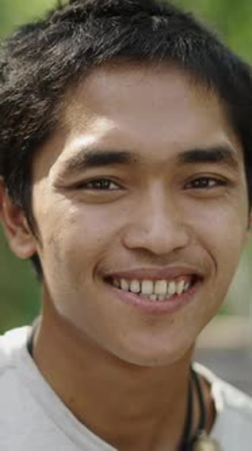 Young Man Smiling in Natural Outdoor Setting