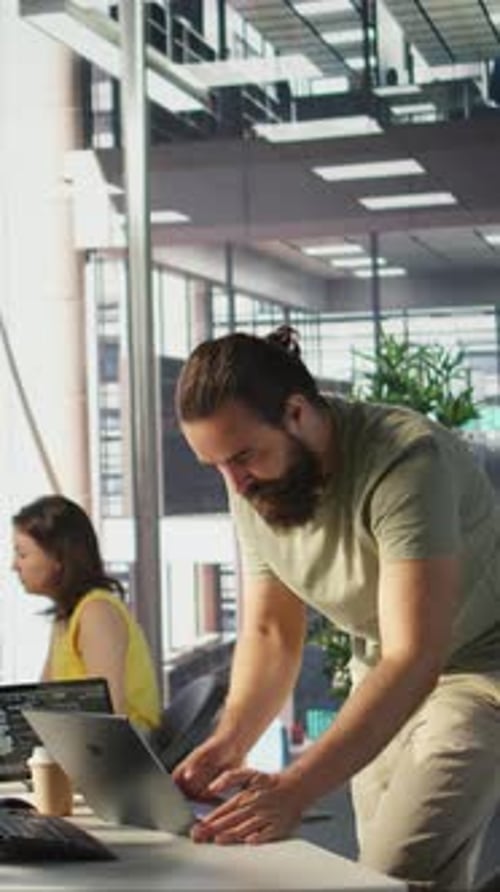 Vertical Video Man Monitoring Company Systems Using Notebook While Standing in Office