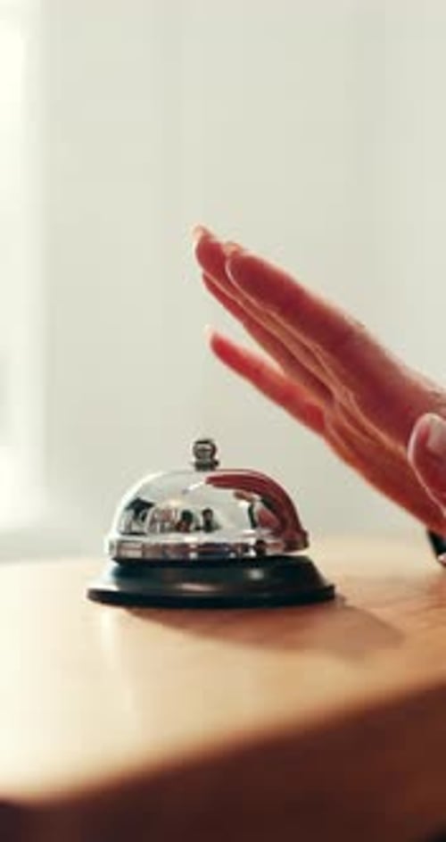 Person, hands and ring with service bell for customer help or assistance on counter in hotel
