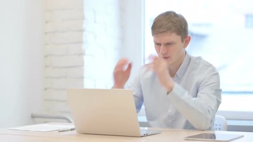 Young Businessman Reacting to Loss While Working in Office